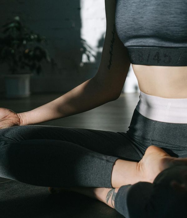 Woman in a calm yoga pose in a bright, minimalist room.